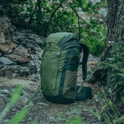 Mochila verde em ambiente de trilhas ou floresta