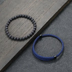 Pulseiras masculinas estilo na cor preto e azul em metal lado a lado.