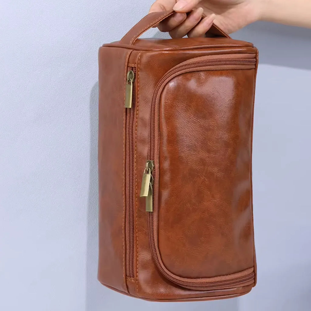 pessoa segurando uma Necessaire Impermeável em Couro na cor marrom, com fundo claro