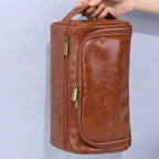 pessoa segurando uma Necessaire Impermeável em Couro na cor marrom, com fundo claro